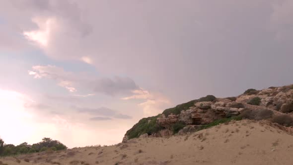 Locked Off View Of Pink Dramatic Sunset Past Rocks And Sand At Beach In Catania, Sicily