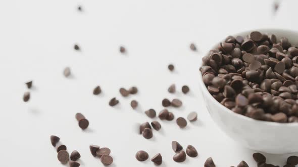 Video of overhead view of bowl of chocolate chip over white background