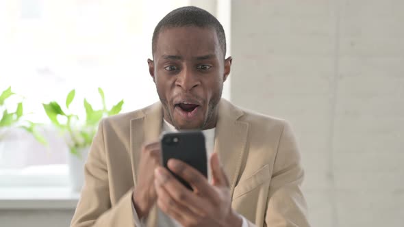 Portrait of African Man Celebrating on Smartphone