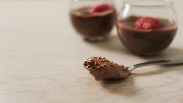 Video of chocolate pudding with strawberries and bluberries on a wooden surface