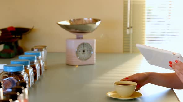 Woman using digital tablet while having coffee 4k