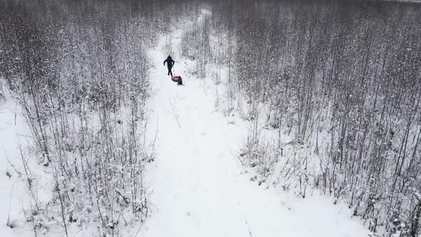 Mom and Child Ride a Tubing in Winter