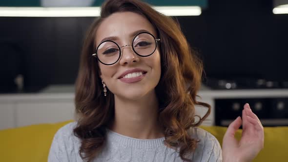Pretty Smiling Woman in Glasses Posing on Camera on the Kitchen Background