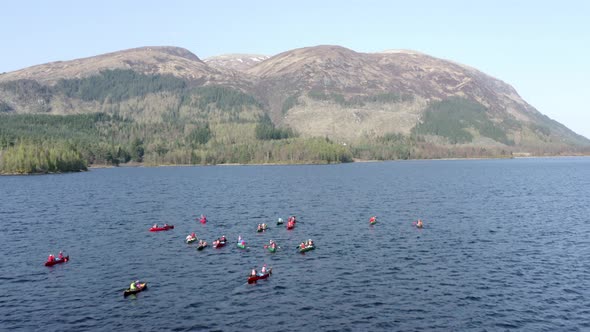 Aerial View of Canoeists in a Lake Surrounded by Mountains and Nature