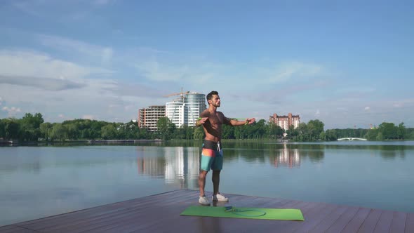 Muscular Young Man with Bare Chest Performs Fitness Exercise