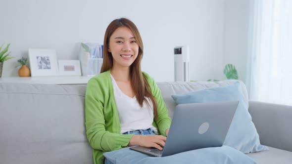 Portrait of Asian beautiful business woman feeling happy and relax using laptop work from home.