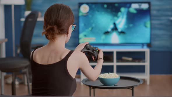 Closeup of Woman Holding Controller Celebrating Victory in Online First Person Shooter Game