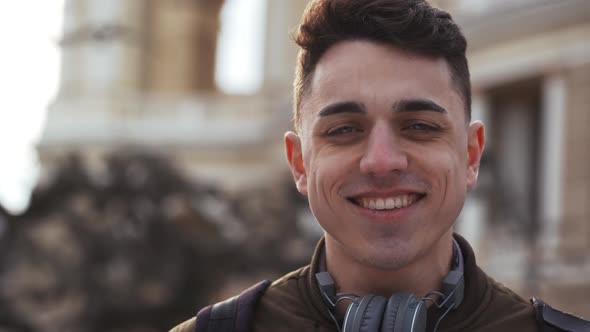 Portrait Closeup of Caucasian Joyful Man 20s Looking at you with Big Sincere Smile While Standing