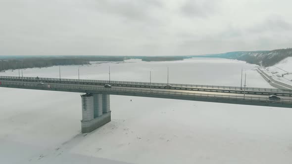 Cars Drive Along Large Modern Bridge Over Frozen River