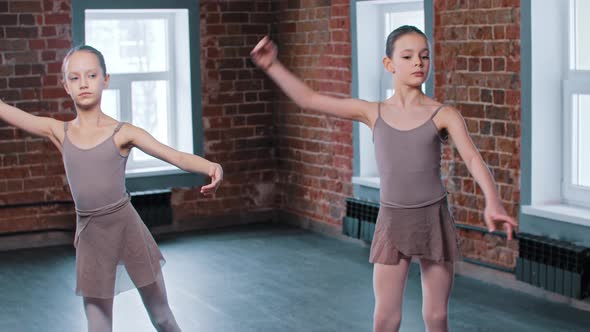 Two Ballerina Girls Train Synchronized Movements in the Studio
