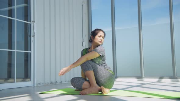 Exercise concept. Middle-aged women stretching in the glass room