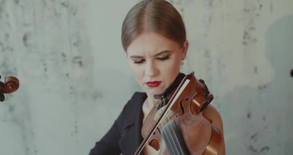 Admiring Female Musician in Black Dress Playing the Violin Emotionally Indoor