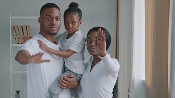 African Family Black Serious Young Afro Parents with Little Daughter Standing Indoor Holding Their