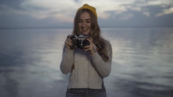 Portrait of Cheerful Young Caucasian Woman Taking Photos on Camera Standing on River Bank on