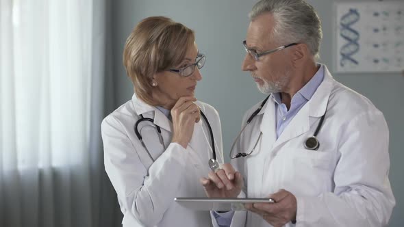 Male Doctor Showing Tablet to His Female Colleague Electronic Medical History