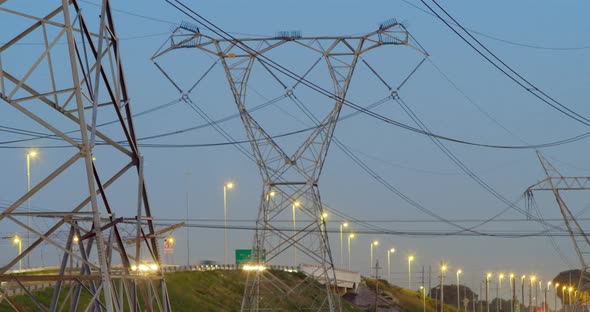 Time lapsed of electricity pylon near highway at dusk 4k