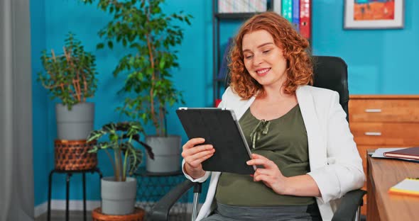 Young Hardworking Pregnant Woman Works in Office Sits Holding Tablet Checks Email Reads Message From