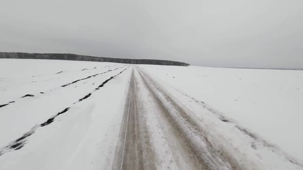 FPV drone view of winter snow-covered dirt road 3