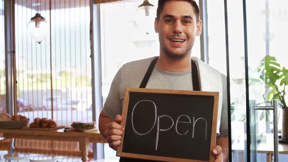 Smiling waiter with chalkboard