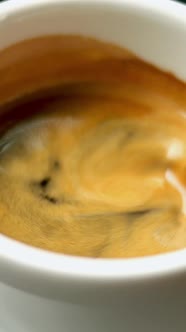 Black Hot Espresso Coffee with Fluffy Foam is Mixed with Metal Teaspoon