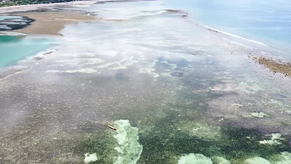 Aerial drone reverse over stunning ocean with coral reefs and sand bars at low tide with crystal cle