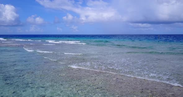 Wide angle overhead copy space shot of a sunshine white sandy paradise beach and blue water backgrou