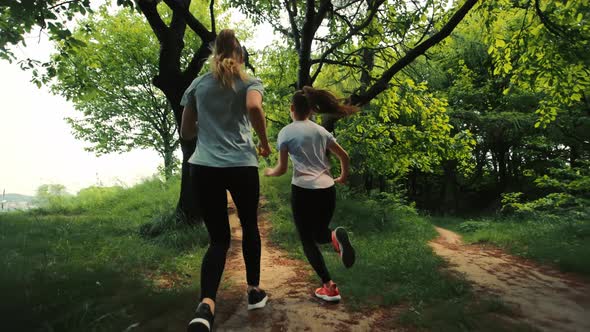 Two Girls Running on a Forest Path Running Two Young Girls Rear View Morning Running Girls Running