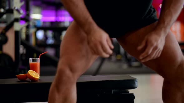 a Sporty Male Bodybuilder Takes a Break From Training By Drinking an Energy Drink in the Fitness