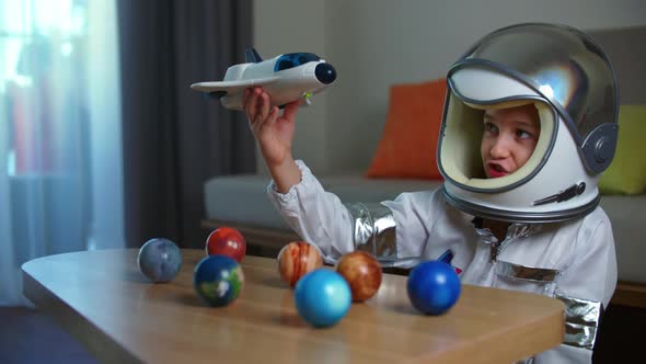 Child Plays at Home in an Astronaut Funny Portrait of a Little Girl 89 Years Old in a Toy Space Suit