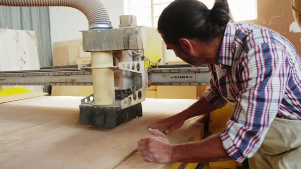 Carpenter using his machine and smiling for camera