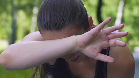 Female Sportsman Runner Wipes Sweat After Hard Training Outdoors, Slow Motion