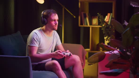Young Man Gamer Wearing Headphones with Microphone Playing Video Game on Tv Gesturing Dislike