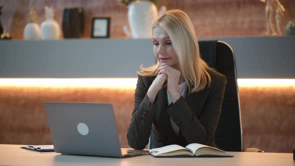 Positive Beautiful Influential Caucasian Mature Woman Top Company Manager Sits in Office Using