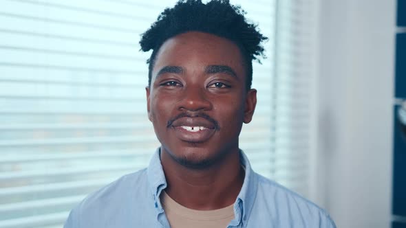 Smiling Young African American Man Looking at Camera Standing at Home Office