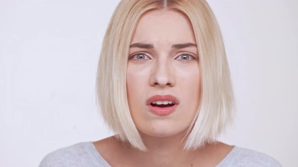 Young Beautiful Upset and Disappointed Blonde Girl Over White Background