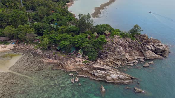 Aerial View of Island Beach with Bungalow and Rocky Coastline at Haad Khom Beach