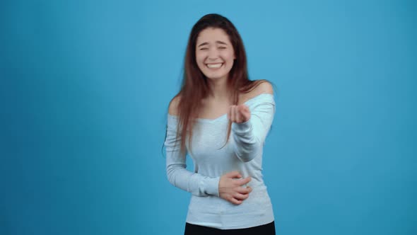 The Portrait of a Young Woman Amused By the Situation Who Laughs with Her Mouth to Her Ears with Her