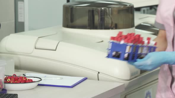 Cropped Shot of a Scientist Taking Notes While Working with Blood Samples