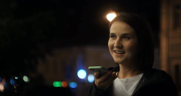 Girl Using Smart Phone Voice Recognition Dictates Thoughts Voice Dialing Message at Night Evening
