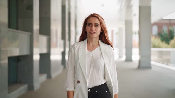 Beautiful business woman with red hair in fashion clothes walk work near office