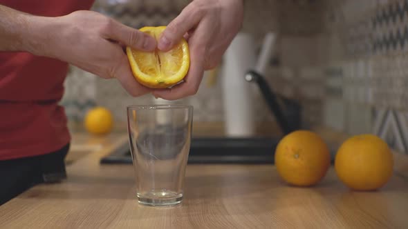 a Man Squeezes an Orange