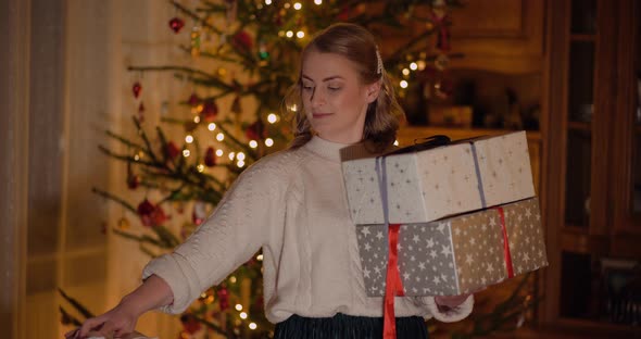 Smiling Woman Holding Christmas Gifts in Hands