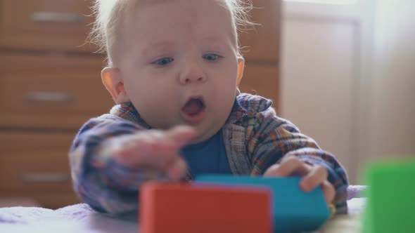 Funny Little Boy Upset of Smashing Cubes Tower on Soft Bed