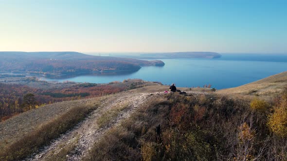 Aerial drone flight over traveler in autumn forest in mountains.