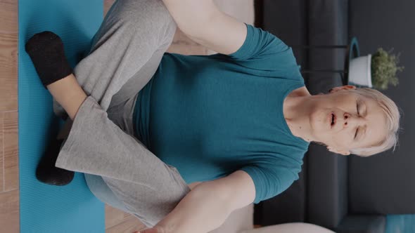 Vertical Video Retired Woman with Closed Eyes Sitting in Lotus Position