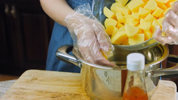 The Cook Puts the Potatoes in the Iron Pot to Boil Them