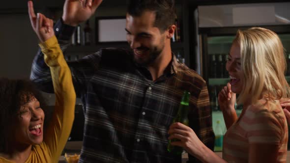 Friends at the bar in a pub dancing and having fun