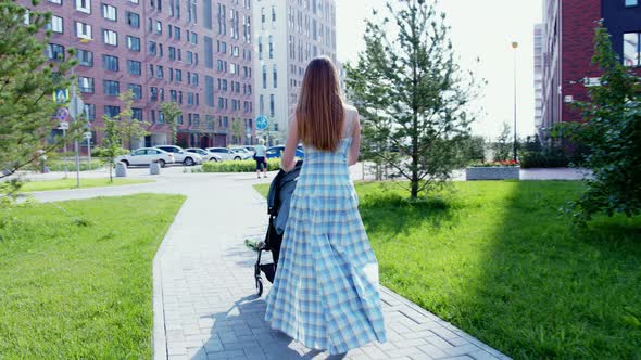 Girl Going on Street with Baby Stroller in Summer