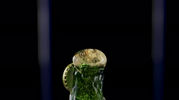 Macro Shot of Cap Popping Out of Green Glass Bottle and Explosion of Splash Carbonated Beer