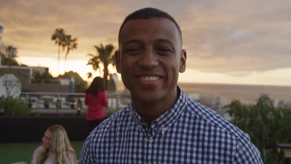 Young African American man smiling at camera on a rooftop